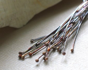 May include: A bunch of thin, metallic wires with rounded ends. The wires are a mix of copper and silver tones.