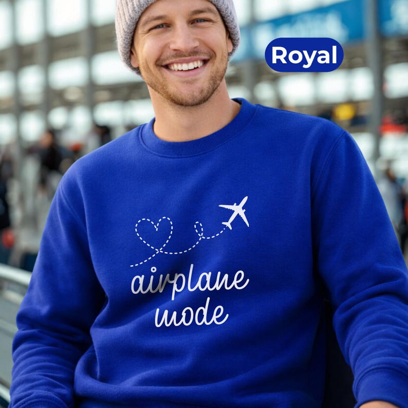 May include: Royal blue sweatshirt with a white airplane graphic and the words "airplane mode". The design includes a heart-shaped dotted line. The sweatshirt is a solid color and has a crew neck.