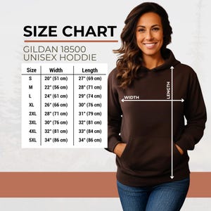 Pu&ograve; includere: Tabella delle taglie per una felpa con cappuccio unisex Gildan 18500. La tabella elenca le taglie dalla S alla 5XL, con le corrispondenti misure di larghezza e lunghezza in cm. Una donna indossa una felpa con cappuccio marrone, mostrando la vestibilit&agrave;.