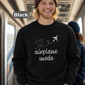 May include: Black crew neck sweatshirt with the words "airplane mode" in white script, along with a heart and airplane graphic. The sweatshirt is a solid black color.