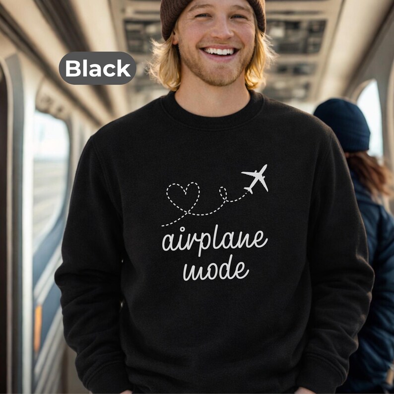 May include: Black crew neck sweatshirt with the words "airplane mode" in white script, along with a heart and airplane graphic. The sweatshirt is a solid black color.