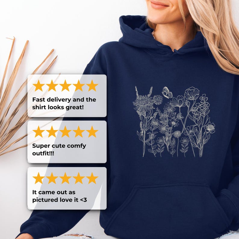 Pu&ograve; includere: Felpa con cappuccio blu navy con un delicato design floreale bianco e una farfalla. La felpa ha una tasca frontale e un cappuccio con coulisse. Il testo sull'immagine dice: "Consegna veloce e la maglietta &egrave; fantastica!"