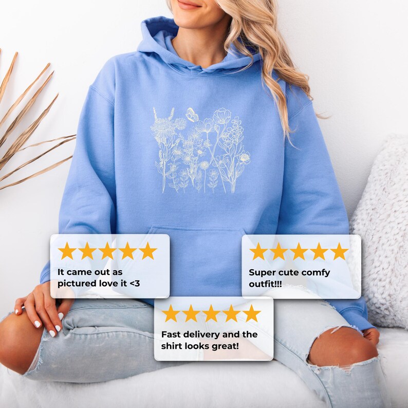 Pu&ograve; includere: Felpa con cappuccio azzurra con un design floreale bianco. La felpa ha un cappuccio con coulisse e una tasca frontale. Il design floreale &egrave; un contorno di fiori e una farfalla. Sono visibili anche le recensioni dei clienti.