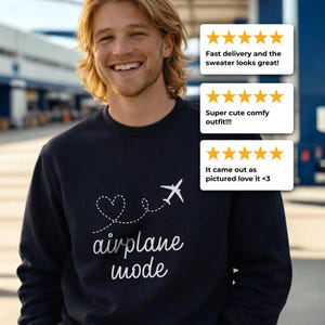 May include: Navy blue sweatshirt with the words "airplane mode" in a cursive font, along with a heart and airplane graphic. The sweatshirt is being worn by a person.