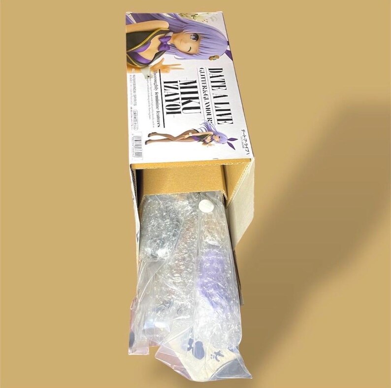 May include: A cardboard box containing a figure from the anime series "Date A Live". The box features illustrations of the character Miku Izayoi, with purple hair and a purple and black outfit. The figure is packaged in plastic.