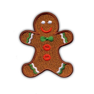 Puede incluir: Parche bordado de hombre de jengibre con contorno marrón, pajarita verde y detalles rojos y blancos. El hombre de jengibre tiene una boca roja sonriente y dos ojos blancos. Ideal para manualidades navideñas.
