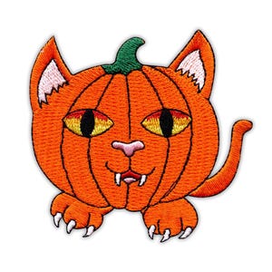 Può includere: Una toppa ricamata che raffigura una zucca arancione stilizzata a forma di testa di gatto. Il design include un picciolo verde, occhi gialli con pupille nere, un naso rosa, zanne bianche e due zampe arancioni con artigli bianchi in basso.