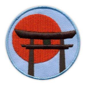 Peut inclure: Écusson brodé représentant un soleil rouge et une porte torii marron foncé sur fond bleu clair. L'écusson a une bordure bleu clair. Le design est inspiré de l'art et de la culture japonais.