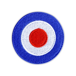 May include: Circular patch with a blue outer ring, a white inner ring, and a red center circle. The patch has a stitched texture and is set against a white background.