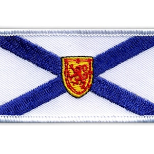 Könnte beinhalten: Gestickter Aufnäher mit der Flagge von Nova Scotia. Das Design umfasst einen weißen Hintergrund mit einem blauen Andreaskreuz und einem goldenen Schild mit einem roten Löwen in der Mitte. Der Aufnäher hat einen weißen Rand.