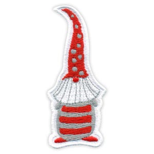 May include: An embroidered patch featuring a gnome with a tall, pointed red hat decorated with grey polka dots. The gnome has a white beard, a round nose, and a body with horizontal red and grey stripes. The patch has a white stitched border.