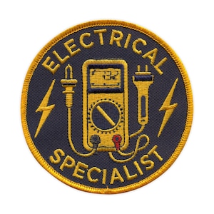 May include: Embroidered patch with the words "ELECTRICAL SPECIALIST" in gold lettering on a navy blue background. The patch features a yellow multimeter, lightning bolts, and gold trim.