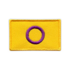 Pode incluir: Um patch retangular amarelo com um círculo roxo no centro. O patch tem uma borda amarela e é provavelmente feito de tecido. O design é simples e arrojado, ideal para costurar.