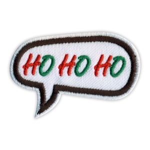 May include: An embroidered patch shaped like a speech bubble with a white background and a dark brown border. The text HO HO HO is stitched in alternating red and green letters across the center of the white speech bubble surface.