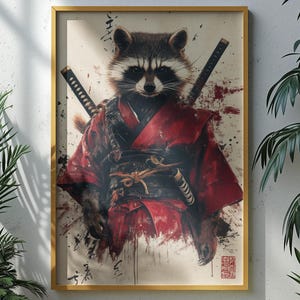 Peut inclure: Impression artistique encadrée d'un raton laveur en tenue de samouraï rouge, avec deux épées. L'œuvre est de style aquarelle avec des éclaboussures rouges et noires. Le cadre doré présente l'impression sur un mur blanc.