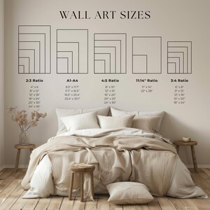 May include: A bedroom scene with a bed featuring neutral-toned bedding. Above the bed, a chart displays wall art sizes in various ratios, including 2:3, A1-A4, 4:5, 11:14, and 3:4, with corresponding inch measurements. The room includes wooden stools and a vase.