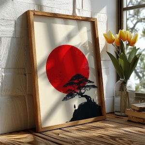Op de afbeelding: Een ingelijste kunstdruk met een rode zon, een zwart silhouet van een boom en figuren op een heuvel. Het kunstwerk staat in een houten lijst en leunt tegen een witte bakstenen muur. Gele tulpen zijn ook zichtbaar.