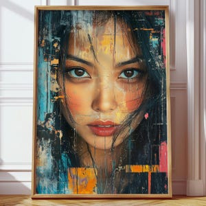 Peut inclure: Une impression d'art encadrée représentant un portrait de femme aux cheveux noirs et aux yeux bruns. L'œuvre d'art a un style abstrait et texturé avec une palette de couleurs de bleus, d'oranges et de noirs. Le visage de la femme est le point central, avec des lèvres rouges et du fard à joues.
