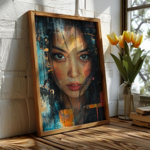 Peut inclure: Un portrait encadré d'une femme aux cheveux noirs et aux yeux bruns. L'œuvre présente un mélange de couleurs, dont le bleu, l'orange et le noir, avec un cadre en bois. La peinture est appuyée contre un mur de briques blanches, avec des tulipes jaunes dans un vase à proximité.