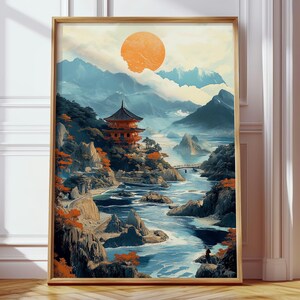 Peut inclure: Impression d'art encadrée d'un paysage japonais avec une pagode, une rivière et des montagnes. L'œuvre utilise une palette de couleurs chaudes avec des tons orange, bleu et vert. Le soleil est un grand cercle orange dans le ciel.