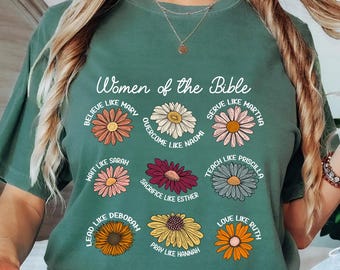 May include: Light green t-shirt with the text "Women of the Bible" and floral designs. Each flower has a different name, such as "Believe like Mary" and "Love like Ruth". The shirt is a solid light green color.