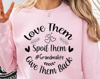 May include: Pink sweatshirt with a black graphic that says "Love Them Spoil Them #Grandmalife Give Them Back" with hearts and leaves around the text.