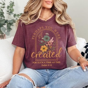 Może przedstawiać: Bordowy t-shirt z kwiatowym wzorem i tekstem "Perhaps you were created for such a time as this Esther 4:14".