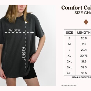 Pu&ograve; includere: Una t-shirt grigio antracite a maniche corte con una tabella delle taglie intitolata Comfort Colors 1717. La tabella elenca le taglie dalla S alla 4XL con le relative misure di lunghezza e larghezza in pollici. Un diagramma mostra come misurare.
