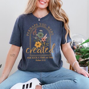 Może przedstawiać: Koszulka w kolorze granatowym z kwiatowym wzorem i tekstem "Perhaps you were created for such a time as this Esther 4:14".