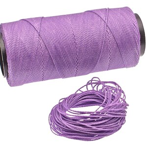 Può includere: Un rocchetto di filo di lino cerato viola, perfetto per la lavorazione del cuoio, la cucitura e altri progetti. Il filo è avvolto attorno a un rocchetto di cartone con un tappo di plastica nero. Un mucchio separato di filo è mostrato nell'angolo in basso a destra dell'immagine.