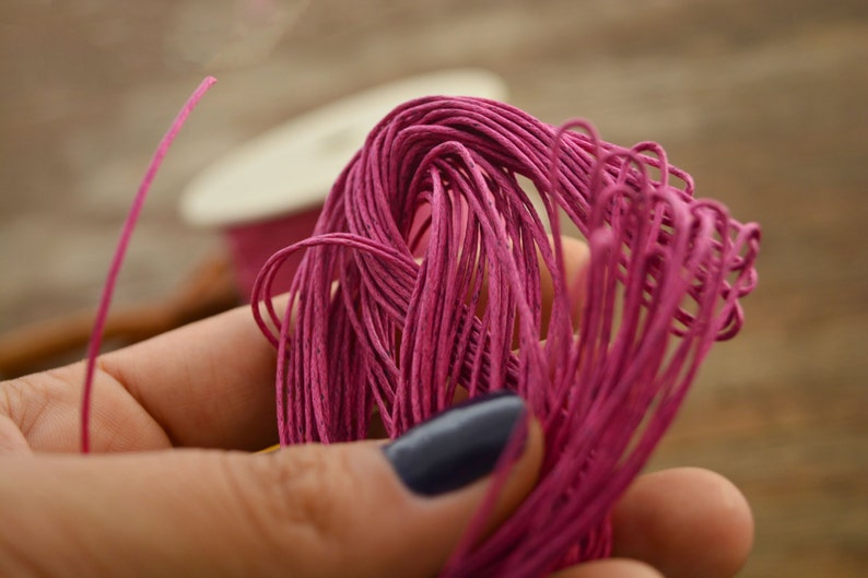 May include: A close-up of a bundle of pink paper cord. The cord is soft and pliable, and it is perfect for crafting projects.