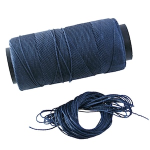 May include: A spool of dark blue thread with a length of thread unwound from the spool.