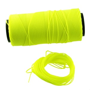 Puede incluir: Una bobina de hilo amarillo brillante, enrollada apretadamente y lista para usarse en proyectos de costura o manualidades.