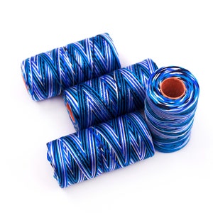 May include: Four spools of blue, white, and black striped thread. The thread is wound around a cardboard spool with a brown center.