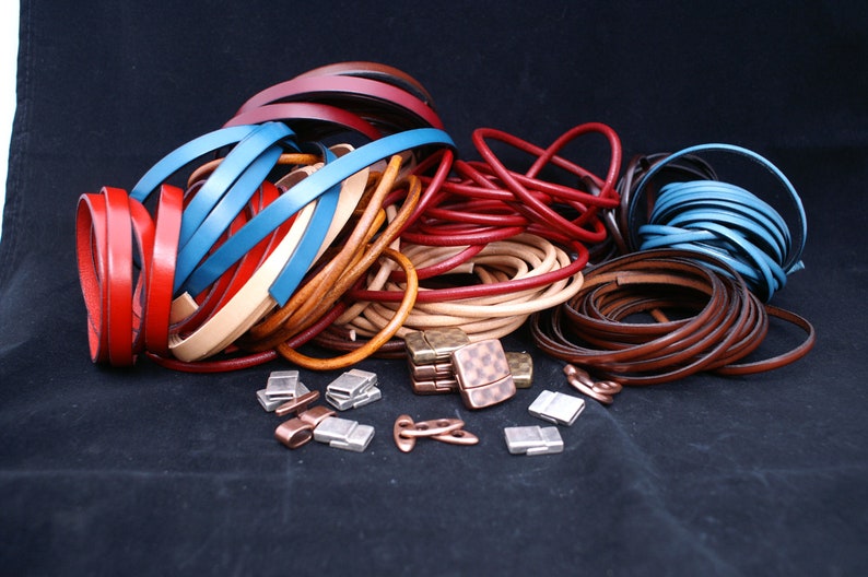Puede incluir: Surtido de cord&oacute;n de cuero en varios colores, incluyendo rojo, marr&oacute;n, beige y azul, con cierres magn&eacute;ticos plateados y de cobre.
