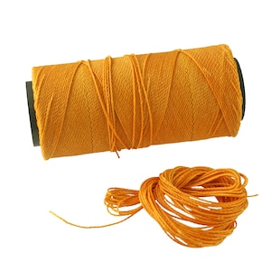 May include: A spool of bright orange thread with a length of thread unwound from the spool.