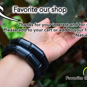 May include: A black bracelet made of round, smooth beads. The bracelet is worn on a person's wrist. The text "Favorite our shop" and "Favorite this item!" is visible in the image. The text "Thanks for your interest and for support! Please add to your cart or add to your favorites. - Nature Beads" is also visible in the image.