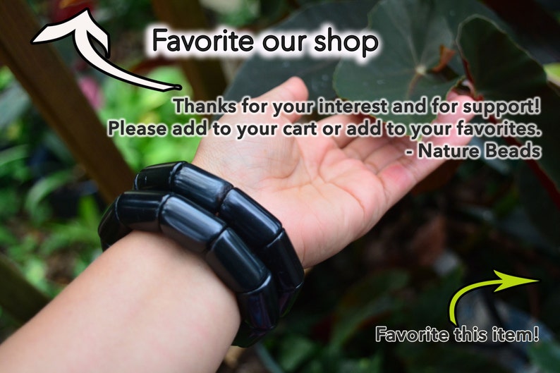 May include: A black bracelet made of round, smooth beads. The bracelet is worn on a person's wrist. The text "Favorite our shop" and "Favorite this item!" is visible in the image. The text "Thanks for your interest and for support! Please add to your cart or add to your favorites. - Nature Beads" is also visible in the image.