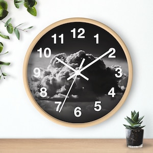 May include: A black and white clock with a wooden frame and a cloudy sky design. The clock face has white numbers and hands.
