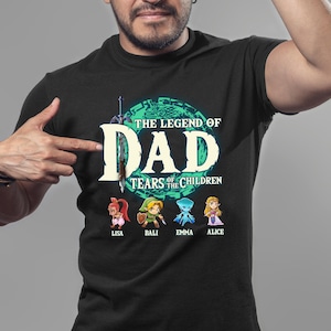 May include: Black t-shirt with a green and blue graphic of a video game character. The text "The Legend of Dad Tears of the Children" is printed on the shirt. The names Lisa, Bali, Emma, and Alice are printed below the graphic.
