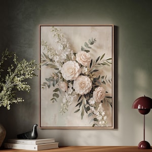 May include: A rectangular framed wall art piece featuring a central floral arrangement of pale pink and white roses, delicate white delphinium spikes, and green eucalyptus foliage set against a textured, neutral-toned beige background.