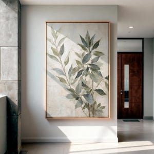 May include: A vertical rectangular wall art piece featuring a painted botanical study of leafy branches in muted shades of sage green, olive, and grey against a textured off-white background, enclosed within a thin light wood frame.
