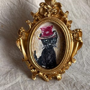 Chat noir drôle dans un chapeau rouge, peinture à l'huile d'inspiration vintage dans un cadre doré, oeuvre d'art à l'huile originale, décoration murale
