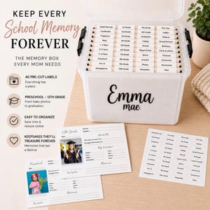 May include: A white memory box with a clear lid, labeled "Emma mae." The box contains labeled dividers for school memories, from baby photos to graduation. Includes pre-cut labels and memory cards.