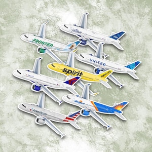 以下が含まれることがあります： JetBlue、Frontier、Delta、Spirit、United、Allegiant、Americanなどの航空会社のロゴが入った飛行機のステッカーのコレクション。ステッカーは白で、詳細なデザインとカラフルなアクセントが施されています。