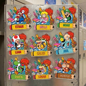 Pu&ograve; includere: Nove calamite acriliche colorate con vari personaggi di Super Mario, ognuna con un nome su una base a forma di matita. Le calamite includono pastelli, libri e zaini, perfette per un tema scolastico o in classe.
