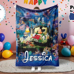 May include: A blue fleece blanket featuring a Disney-themed illustration with Mickey Mouse reading in bed. The blanket has the name "Jessica" in white script. Colorful balloons and a "Printed in the USA" sticker are in the background.