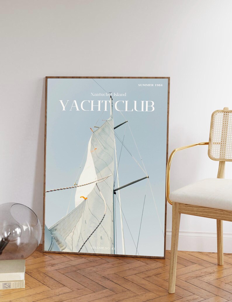 May include: A framed poster with a blue and white sailboat against a light blue sky. The poster has the text "Nantucket Island Yacht Club" and "Summer 1981" printed on it.