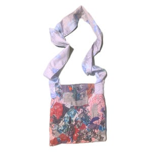 May include: A patchwork shoulder bag with a long strap. The bag's body is a collage of fabric pieces in various colours, including red, blue, and pink. The strap is a light blue fabric with a floral pattern.