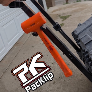 May include: An orange rubber mallet with a textured handle, leaning against a black cart. The mallet has the word "HARDEN" printed on it. The image also includes a logo that says "PackKlip".